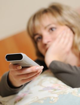 The woman with a television control panel. House conditions. Selective focus