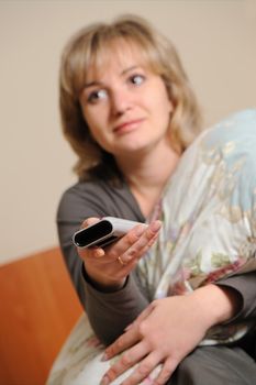 The woman with a television control panel. House conditions. Selective focus