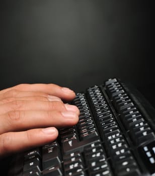 Hands above the keyboard. On a dark background, the black keyboard