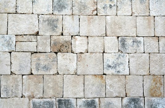 A closeup of a stone wall at Chichen Itza.
