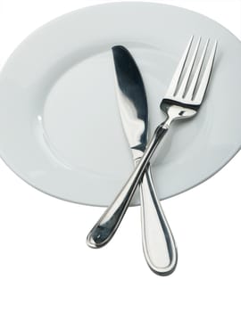 Knife and fork on a plate. Kitchen accessories close up