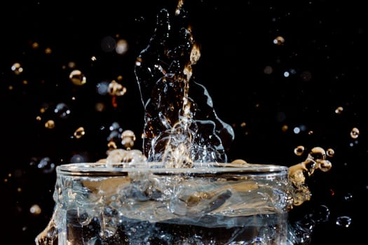 The fluid motion of water being poured into a glass of water forming abstract shapes