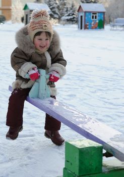 The girl on a swing. Winter, solar frosty weather