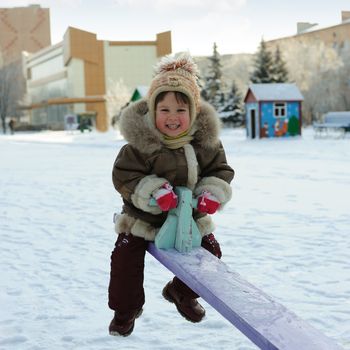 The girl on a swing. Winter, solar frosty weather