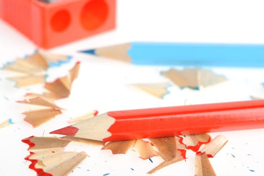 Color pencil and sharpener with a shaving. It is isolated on a white background