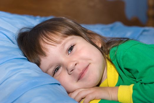 The little girl on a bed. The three-year child of the European nationality