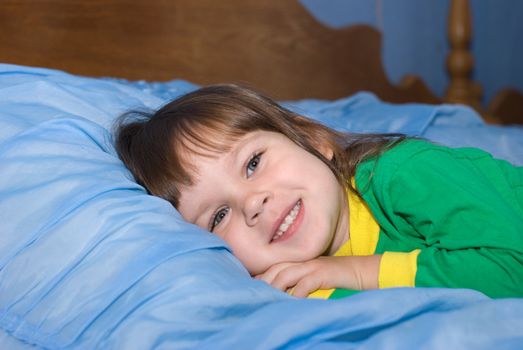 The little girl on a bed. The three-year child of the European nationality