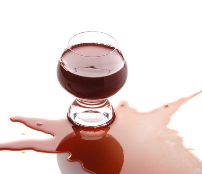The spilled red wine. Wine poured on a surface, is isolated on a white background