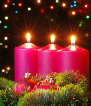 Christmas evening. A composition from candles, New Year's toys on a dark background