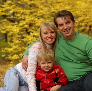 Family. Mum, the daddy, the son in autumn forest. Effective blur a background