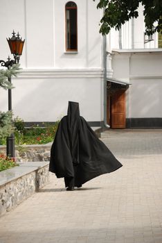 The running monk. The man in a cassock - the novice of a man's monastery