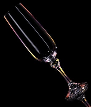 Wine glass. An empty glass on a dark background, with multi-coloured illumination