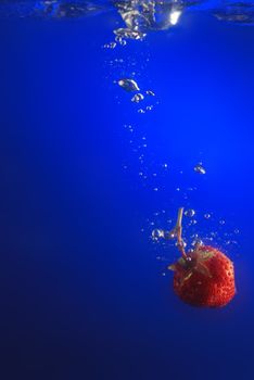 Strawberry in water. A falling berry in cold water.