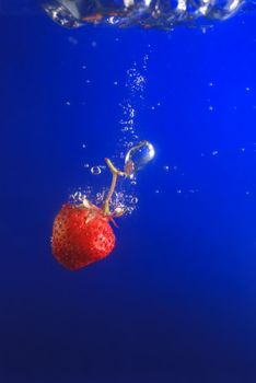 Strawberry in water. A falling berry in cold water.