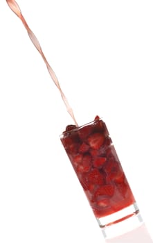 Strawberry juice. A fresh fruit juice flowing in a glass. In a glass the cut fruit
