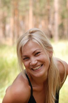 The girl  blonde. In a black blouse and a happy smile on the person