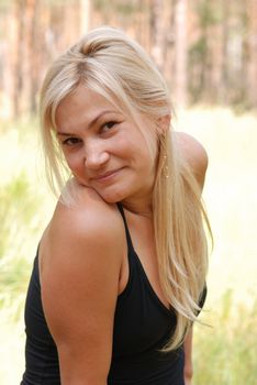 The girl  blonde. In a black blouse and a happy smile on the person