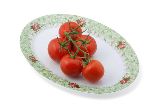 Tomato isolated at dish. It is isolated on a white background. A ripe vegetable.