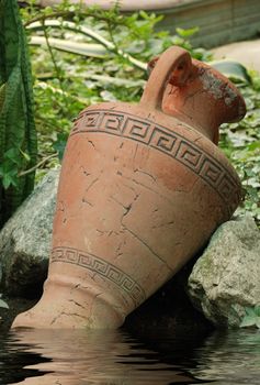 Ancient amphora. An ancient clay vessel among stones