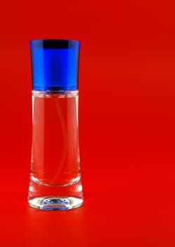 perfume. A bottle perfume on a red background with effective illumination