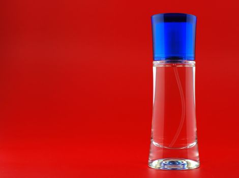 perfume. A bottle perfume on a red background with effective illumination