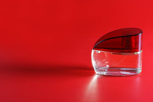 perfume. A bottle perfume on a red background with effective illumination