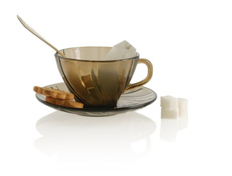 empty glass transparent cup with cookie, sugar anf package tea. Heat-tolerant utensils 
