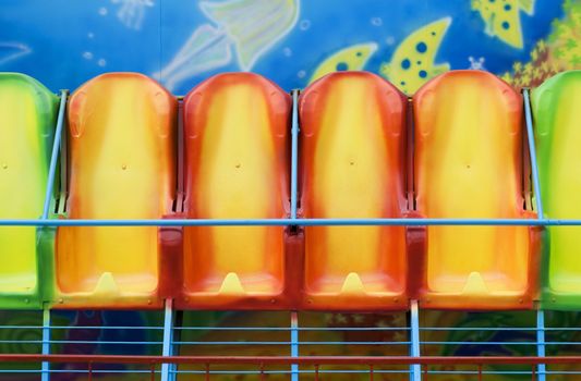 Multi-coloured seats. An old mobile attraction