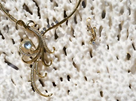 Gold necklace on a background from a sea coral