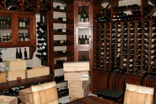 A bunch of wine bottles in racks in a wine cellar.
