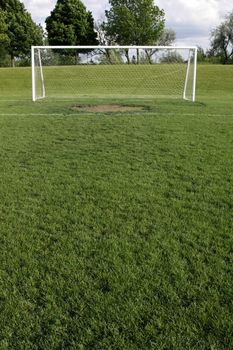 A view of a net on a vacant soccer pitch.