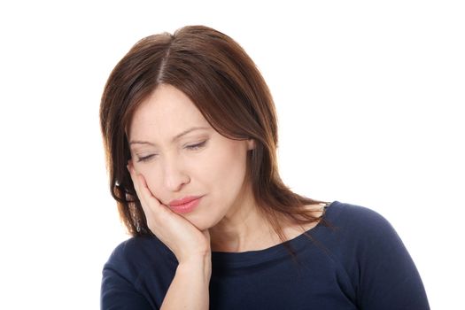 Attractive woman in her 40s pressing her bruised cheek with a painful expression as if she's having a terrible tooth ache.