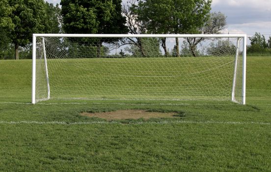 A view of a net on a vacant soccer pitch.
