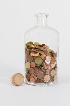 different coins in glass bottle