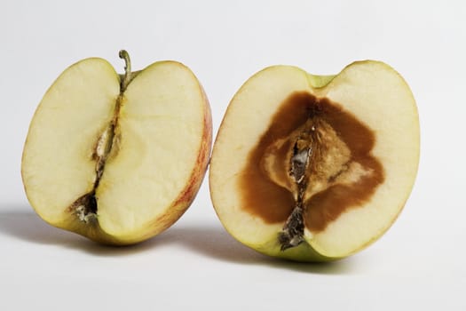 two devided apples. One is rotten from the inside