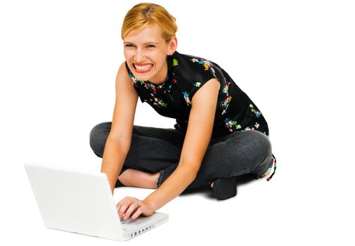 Portrait of a woman using a laptop and smiling isolated over white