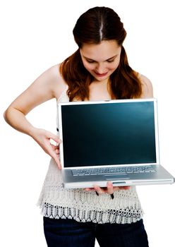 Young woman showing a laptop and smiling isolated over white