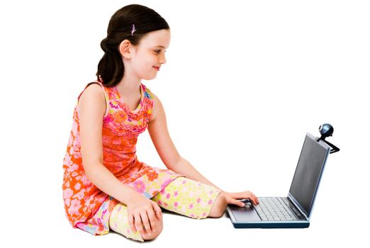 Smiling girl using a laptop and posing isolated over white