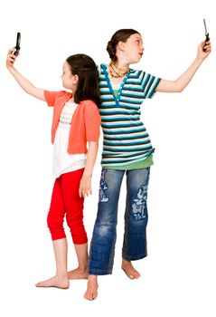 Two girls photo messaging on mobile phones isolated over white