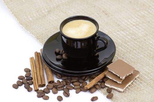 cup of italian espresso with cinnamon, coffee beans and chocolate