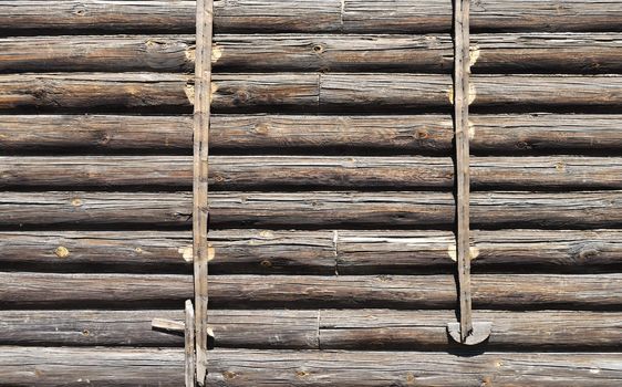 Fragment of old log wall background of abandoned wooden house