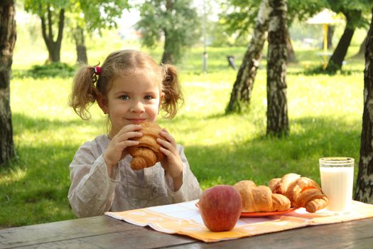 young girl eat croissant