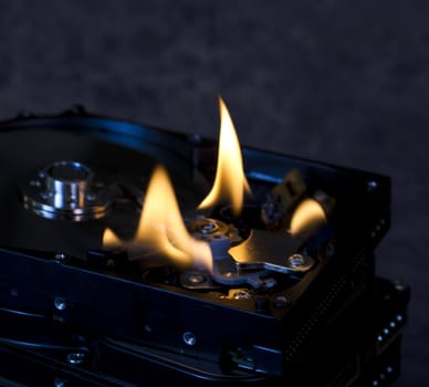 stack of hard drives with top drive open and burning