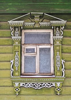Carving decorated window in old country wooden house with freezing patterns, Russia