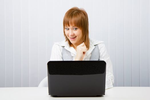 joyful surprise a girl with a laptop in the office
