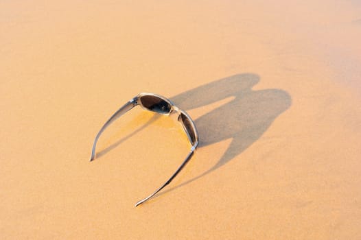 Sun glasses on the sandy sea shore
