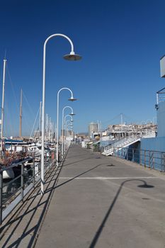 port of Genova with promenade between boats and ships