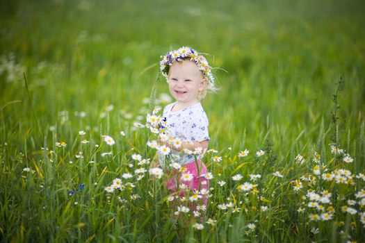 child with flowers in the field