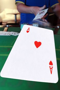 poker player throwing in cards with the ace of hearts in the foreground