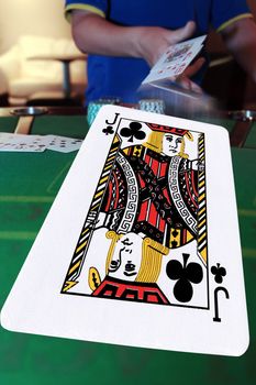 poker player throwing in cards with the jack of clubs in the foreground
